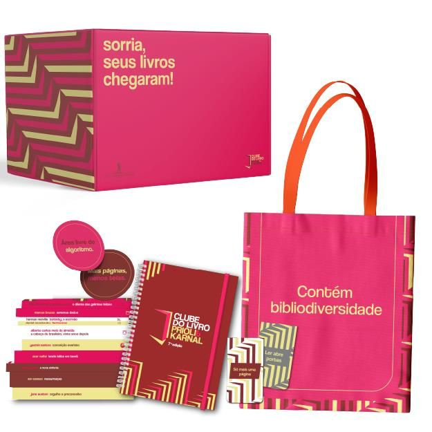 Flat‑lay do Box Clube do Livro 2026: 10 livros com sobrecapas exclusivas, 1 volume extra, planner, ecobag, marcadores magnéticos, suporte de livros, vela aromática e caneca personalizada.