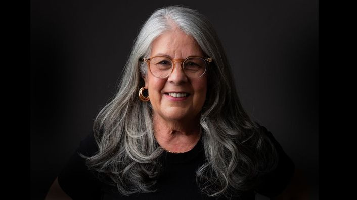 Cláudia Alves, gerontóloga, ao lado de uma idosa com Alzheimer, transmitindo carinho e apoio no método LoveCare 2.0.